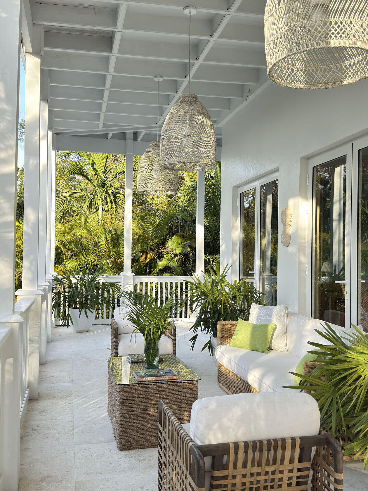 Covered veranda with woven pendant lights overlooking gardens