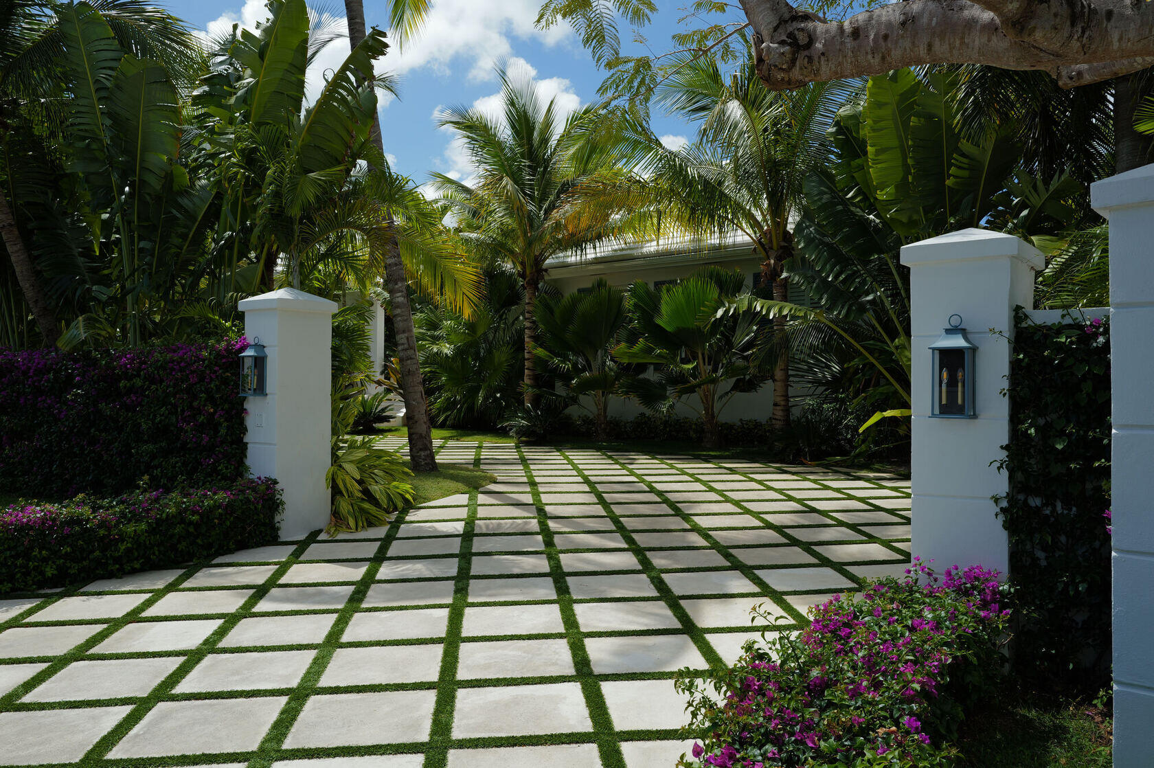 Checkerboard garden path framed by bougainvillea and palms